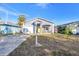 Newly renovated gray house with yellow door, white porch and a fenced yard at 1410 Prescott S St, St Petersburg, FL 33712