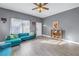 Living room with teal sectional sofa, wood floors, and ceiling fan at 1410 Prescott S St, St Petersburg, FL 33712