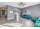 Living room with teal sectional sofa, wood floors, and ceiling fan at 1410 Prescott S St, St Petersburg, FL 33712