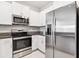 Modern kitchen with stainless steel appliances and white cabinets at 14341 Editors Note St, Ruskin, FL 33573