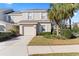 Two-story tan house with white shutters, a garage, and landscaping at 14935 Skip Jack Loop # 106, Lakewood Ranch, FL 34202