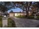 Updated home exterior at night, showcasing landscaping and a paved driveway at 1690 74Th N Ave, St Petersburg, FL 33702