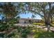 Ranch-style home with lush landscaping and large trees at 1690 74Th N Ave, St Petersburg, FL 33702