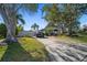 Single-story home with driveway and mature trees at 1690 74Th N Ave, St Petersburg, FL 33702