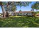 Single-story home with mature trees and well-manicured lawn at 1690 74Th N Ave, St Petersburg, FL 33702