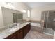 Spacious bathroom with granite countertops, double sinks, and a soaking tub at 18398 Aylesbury Ln, Land O Lakes, FL 34638