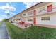 Front view of a condo building with red accents and a grassy area at 1950 58Th N Ave # 9, St Petersburg, FL 33714