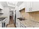 Galley kitchen with granite countertops and white cabinets at 1950 58Th N Ave # 9, St Petersburg, FL 33714