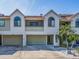 Two-story condo building with attached garages and palm trees at 2372 Hanover Dr, Dunedin, FL 34698