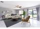 Light-filled living room with a comfortable sectional sofa, decorative rug, and sliding glass doors to the patio at 2372 Hanover Dr, Dunedin, FL 34698