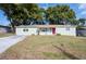 Charming light green house with a red door and well-maintained lawn at 27103 Wakefield Dr, Brooksville, FL 34602