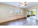 Bright Gathering room featuring hardwood floors, sliding glass doors to a screened porch, and a ceiling fan at 27103 Wakefield Dr, Brooksville, FL 34602