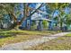 Two-story blue house with a large tree, black fence and stone pathway at 2751 2Nd S Ave, St Petersburg, FL 33712