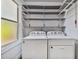 Laundry room with Whirlpool washer and dryer and overhead shelving at 2751 2Nd S Ave, St Petersburg, FL 33712