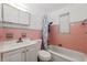 Retro bathroom with pink tile, white vanity, and bathtub at 2809 49Th N St, St Petersburg, FL 33710