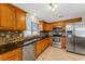 Kitchen with wood cabinets, granite counters, and stainless steel appliances at 2826 Kavalier Dr, Palm Harbor, FL 34684