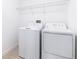 Bright laundry room with washer, dryer, and overhead shelving at 31349 Cabana Rye Ave, San Antonio, FL 33576