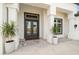 Gray double front doors with sidelights and planters at 3571 Recurve Cir, Sarasota, FL 34240