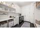 Bright laundry room with built-in shelving, sink, and modern washer/dryer at 3571 Recurve Cir, Sarasota, FL 34240