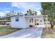 White mobile home with carport and landscaping at 37418 Hammond Dr, Zephyrhills, FL 33541