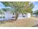 Mobile home with covered patio and large shade tree at 37418 Hammond Dr, Zephyrhills, FL 33541