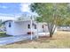 White mobile home with covered patio and driveway at 37418 Hammond Dr, Zephyrhills, FL 33541