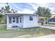 Front view of a white mobile home with covered patio at 37418 Hammond Dr, Zephyrhills, FL 33541