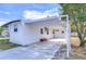 White mobile home with carport and landscaped yard at 37418 Hammond Dr, Zephyrhills, FL 33541