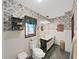 Bathroom with tiled floor, vanity, toilet, and patterned wallpaper at 4001 Keene Rd, Plant City, FL 33565