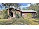 Rustic wood home with red trim, screened porch, and satellite dish at 4001 Keene Rd, Plant City, FL 33565