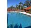 Inviting community pool with lounge chairs and umbrellas at 407 Lake Point Ct # 4E, Sun City Center, FL 33573