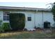 Rear view of house showing door, window, AC unit and landscaping at 407 Lake Point Ct # 4E, Sun City Center, FL 33573