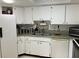 White kitchen with ample cabinet space and a corner sink at 407 Lake Point Ct # 4E, Sun City Center, FL 33573