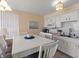 Kitchen with white cabinets, and a table with six chairs at 4316 Tahitian Gardens Cir # H, Holiday, FL 34691