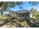 Home with a screened pool and lush green backyard at 4996 Felecity Way, Palm Harbor, FL 34685