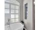 Modern bathroom with a free-standing tub, large window with plantation shutters, and a walk-in shower at 4996 Felecity Way, Palm Harbor, FL 34685