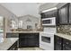 Modern kitchen featuring white appliances and dark wood cabinetry at 4996 Felecity Way, Palm Harbor, FL 34685