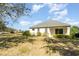 Backyard view showcasing a large lawn, home's exterior, and a peaceful pond view at 5004 Brickell Park Cv, Bradenton, FL 34211