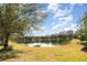 Serene pond view with lush landscaping and mature trees, offering a tranquil setting at 5004 Brickell Park Cv, Bradenton, FL 34211