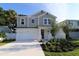 Two-story home with gray siding, landscaping, and a two-car garage at 507 N Bradford Ave, Tampa, FL 33609