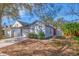 Newly painted light gray house with a red front door and well-maintained lawn at 5605 Tanagergrove Way, Lithia, FL 33547