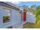 Inviting front entrance with red door, updated landscaping, and gray exterior at 5605 Tanagergrove Way, Lithia, FL 33547