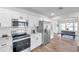 Modern kitchen with white cabinets, stainless steel appliances, and a farmhouse sink at 6629 Travis Blvd, Tampa, FL 33610