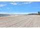 Expansive beach view with clear water and distant bridge at 887 S Gulfview Blvd, Clearwater Beach, FL 33767