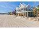 Beachfront home exterior, two stories with covered porch and board-up at 887 S Gulfview Blvd, Clearwater Beach, FL 33767