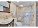 Bathroom featuring a glass-door shower, tiled walls, a grab bar, and a dark wood vanity at 8950 Park Blvd # 406, Seminole, FL 33777