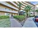 View of the condominium's exterior, highlighting the walkway, garden, and covered entrance at 8950 Park Blvd # 406, Seminole, FL 33777