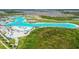 Aerial view of a crystal-clear lagoon with sandy beaches, water activities, and lounge areas at 9114 Forge Breeze Loop, Wesley Chapel, FL 33545