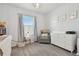 Bedroom featuring a crib, glider chair, and changing table at 9114 Forge Breeze Loop, Wesley Chapel, FL 33545