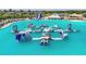 Lagoon with inflatable obstacles and a waterslide at 9114 Forge Breeze Loop, Wesley Chapel, FL 33545